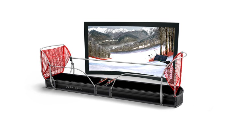 A SkyTechSport Ski Simulator shown in full profile against a white studio background, featuring a wide motion platform with ski bindings, red safety net side guards, a silver safety rail, and a large widescreen display showing an alpine ski slope.